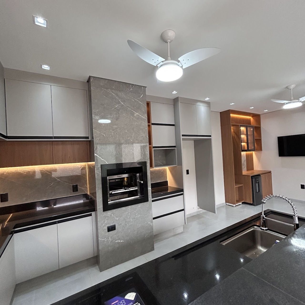 Cozinha gourmet planejada com iluminação em LED e cristaleira